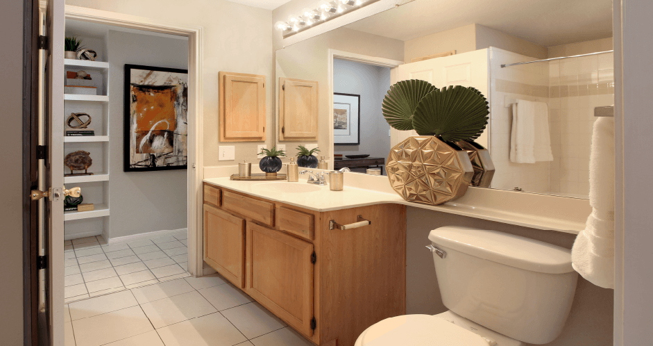 Luxury apartments with spacious bathrooms with tiled floors and showers, oval soaking tub, granite countertop, washed oak cabinets, and built-in bookshelves in north Dallas at Kensington Square Apartments.